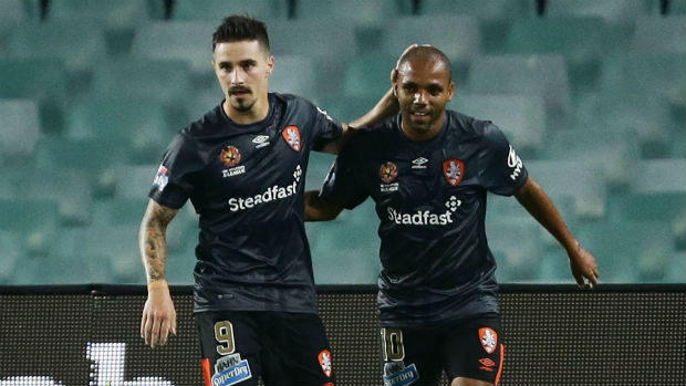 Jamie Maclaren and Henrique celebrate combining for Brisbane's third goal against Sydney.