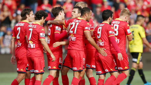 Adelaide United players celebrate scoring against Wellington in Round 12.