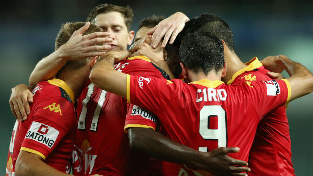 Adelaide United players celebrate scoring against Sydney FC on Saturday night.