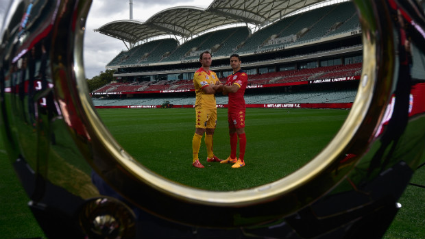 Adelaide United's Eugene Galekovic and Marcelo Carrusca stare through the Hyundai A-League Championship trophy.