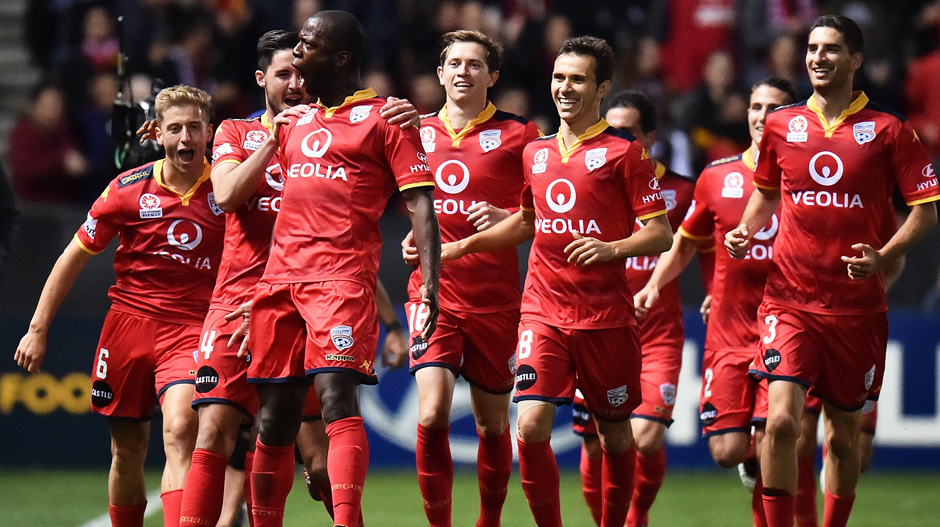 Adelaide United players celebrate one of Bruce Djite's goals in their win over Melbourne City.