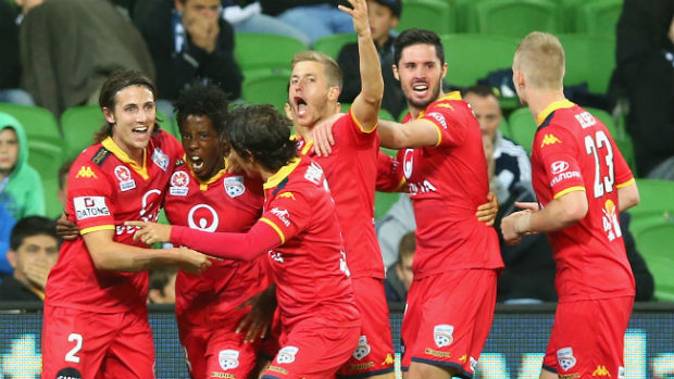 Adelaide United players celebrate Bruce Kamau's late winner against Victory on Friday night.