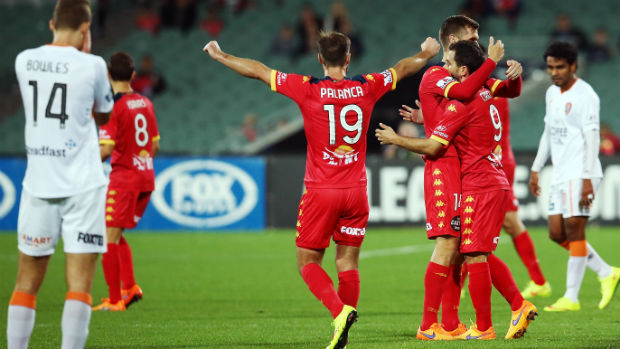 Adelaide United players celebrate their win over Brisbane Roar.
