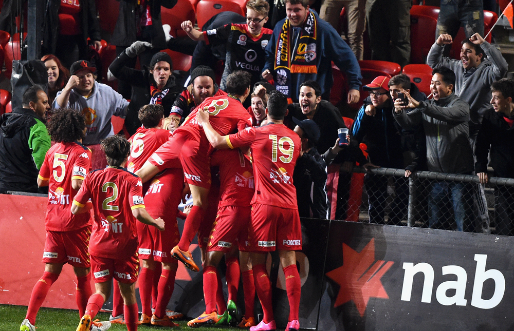 The Adelaide United players celebrating Dylan McGowan's winner in front of the Red Army.