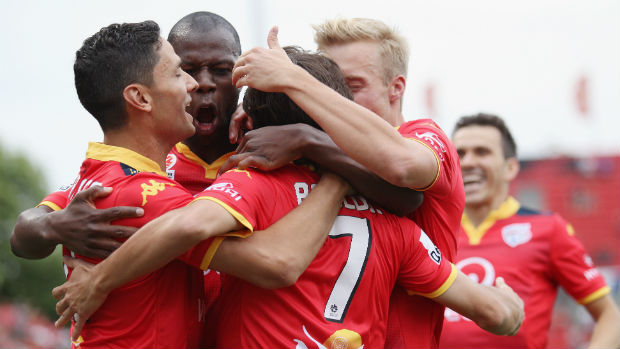 Adelaide United players celebrate opening the scoring against Glory at Coopers Stadium.