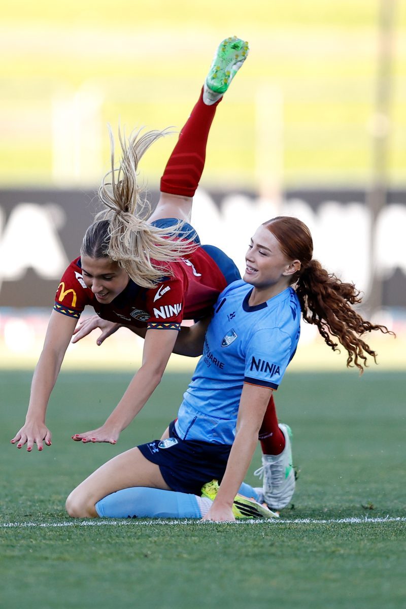 Poppy Channing of Sydney FC competes with Holly Murray of Adelaide United at Sydney Olympic Park Athletic Centre.