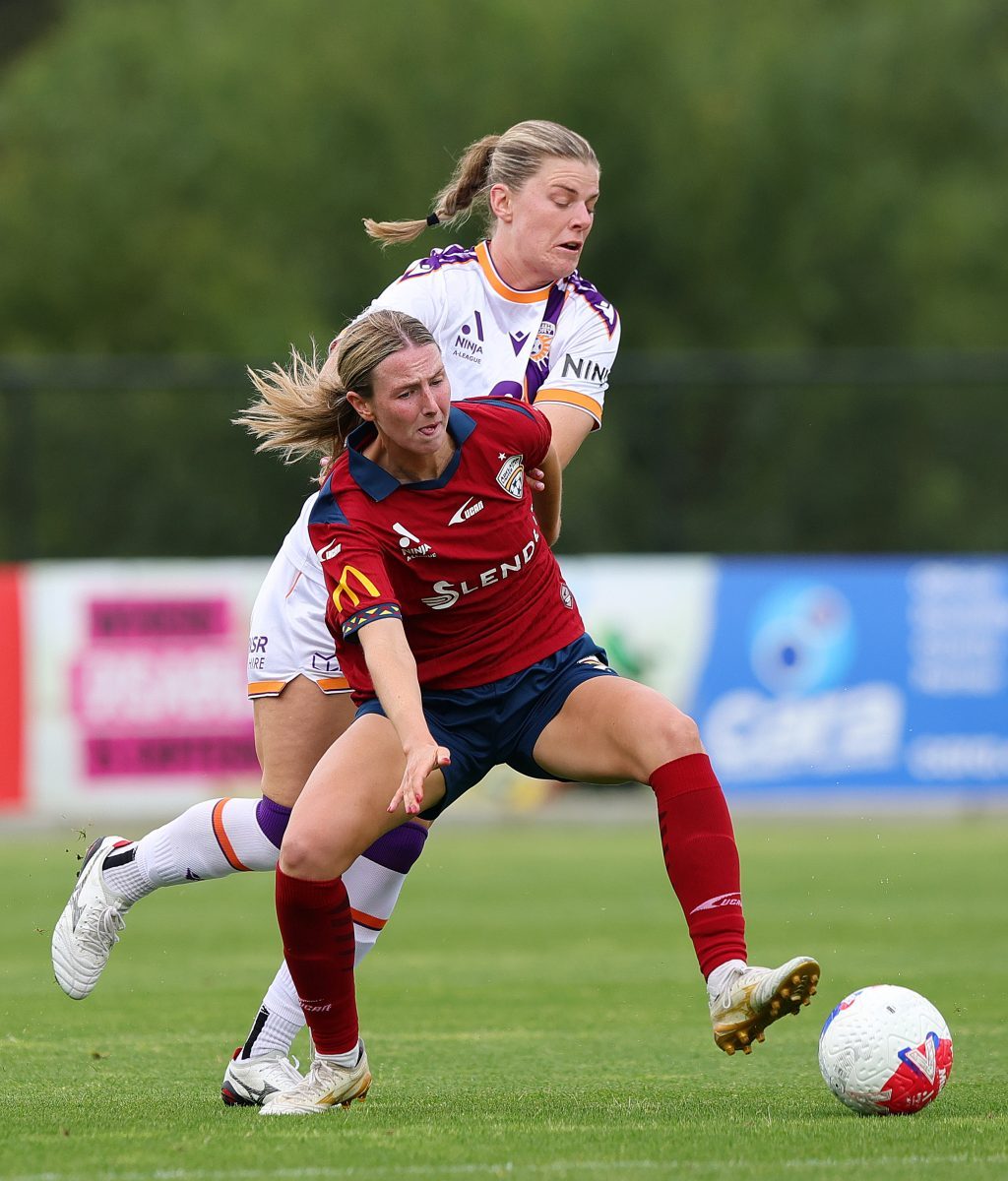 Chelsea Dawber of Adelaide United. and Baxter Thew of Perth Glory at Service FM Stadium.